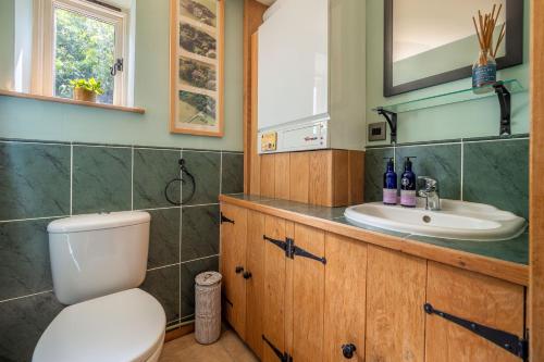 a bathroom with a toilet and a sink at The Granary, Dunstall Green in Denham
