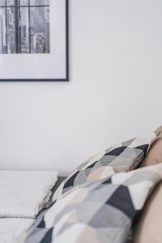 a bed with a black and white pillow and a picture at City Center Lofts in Vienna