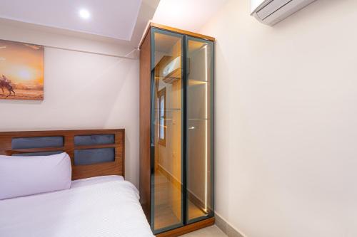 a bedroom with a glass cabinet next to a bed at Zahira Pyramids View in Cairo