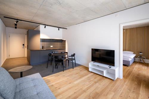 a living room with a couch and a tv and a table at Aparthotel Il Momento Bern Expo - Self Check-In Hotel in Bern