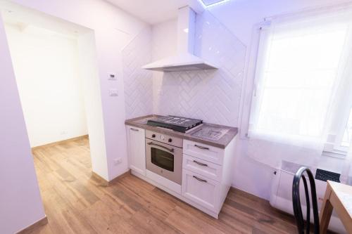 a small kitchen with a stove and a window at La Casetta in Comacchio
