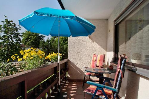 a pair of chairs and a table with an umbrella on a balcony at Ferienwohnung Wölk in Sonthofen