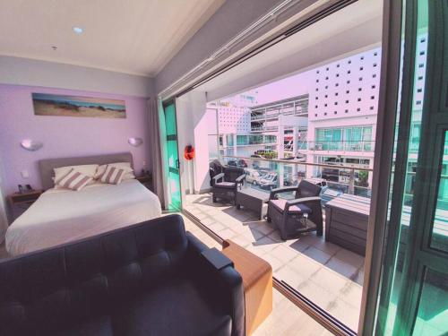 ein Hotelzimmer mit Bett und Balkon in der Unterkunft BRAND NEW! Modern amazing 1Bed - Princes Wharf in Auckland
