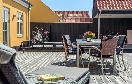 スケーエンにある4 Bedroom Cozy Home In Skagenのデッキにテーブルと椅子が置かれたパティオ