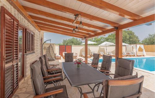 un patio con tavolo e sedie e una piscina di 4 Bedroom Awesome Home In Sibenik a Piramatovci