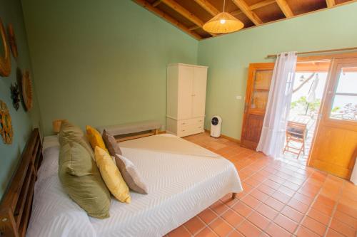 a bedroom with a white bed with pillows on it at Casa la Roseta in Alajeró
