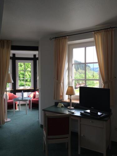 a room with a desk with a computer and a window at Landhotel Menke in Brilon