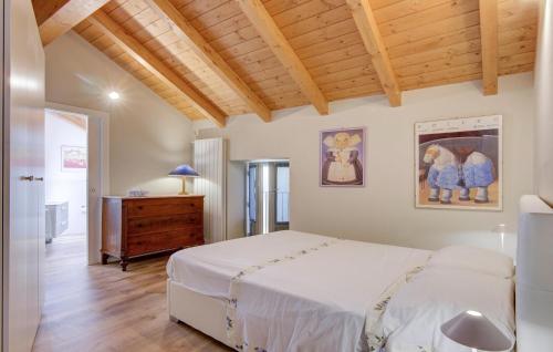 a bedroom with a white bed and a wooden ceiling at Awesome Home In Albagnano Di Bee in Bee