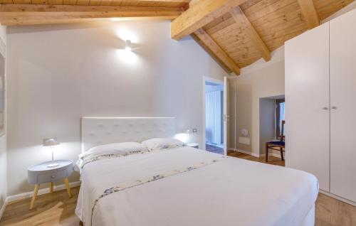 a bedroom with a large white bed and wooden ceilings at Awesome Home In Albagnano Di Bee in Bee