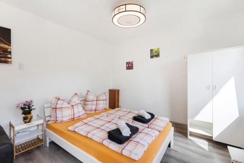 a white bedroom with a bed with pillows at Ferienhaus Sonne in Nordhausen