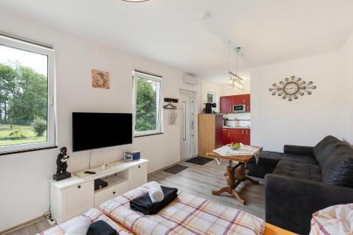 un soggiorno con un divano e una TV di Ferienhaus Sonne a Nordhausen