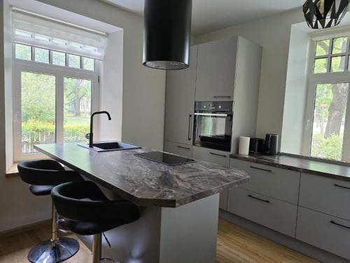a kitchen with a counter with two stools in it at Endla appartement in Viljandi