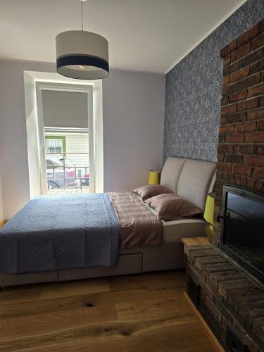 a bedroom with a bed and a fireplace and a television at Endla appartement in Viljandi