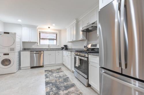 a kitchen with white cabinets and a stainless steel refrigerator at Entire Apt Near Wharf in Boston