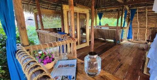 a room with benches and a table with a bottle at Chole Mjini Treehouses Lodge in Utende