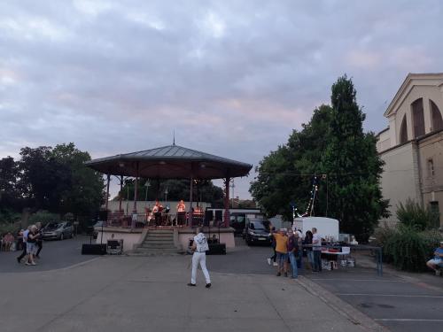 Un groupe de personnes debout autour d'un kiosque à musique dans un parking dans l'établissement segura, à LʼIsle-Jourdain