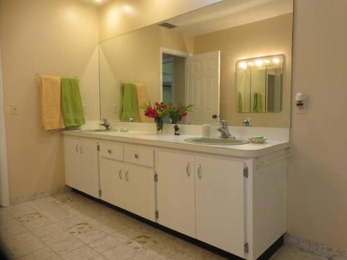 a bathroom with two sinks and a large mirror at Spacious villa, pool, water views, walk to beach in West Palm Beach