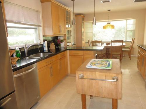 a kitchen with wooden cabinets and a table in it at Spacious villa, pool, water views, walk to beach in West Palm Beach