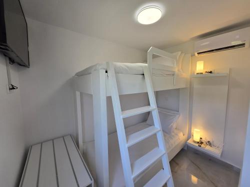 a white bunk bed with a ladder in a room at Elite Country House in Ialyssos