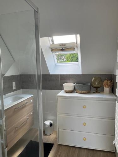 La salle de bains est pourvue d'un lavabo et d'une lucarne. dans l'établissement Au bord de la mer, à Ploubazlanec