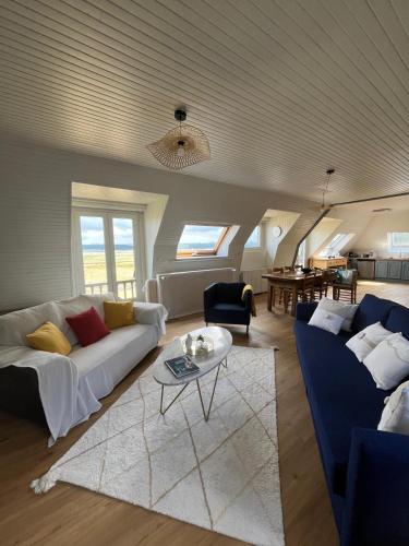 un salon avec deux canapés et une table dans l'établissement Au bord de la mer, à Ploubazlanec