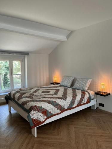 a bedroom with a bed with two lamps on two tables at Habitat in Momignies