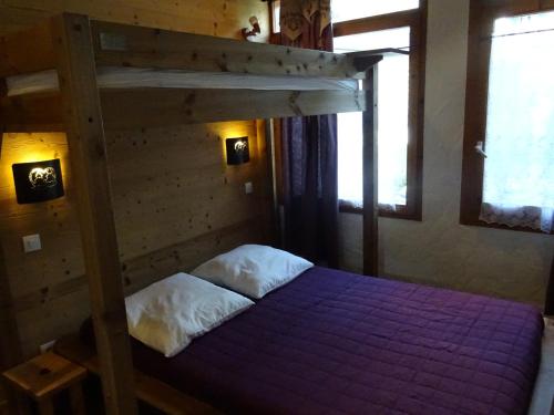 - une chambre avec des lits superposés et une couette violette dans l'établissement Charmant 3 pièces rénové avec terrasse, 6 pers., Bourg Saint Maurice - FR-1-411-606, à Bourg-Saint-Maurice