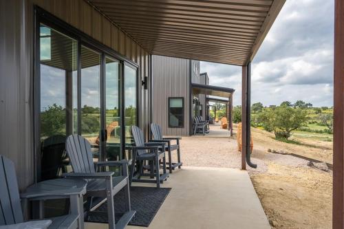 a patio with chairs and a table and windows at Stevie Ray In The Hill Country - Hacienda Amor in Johnson City