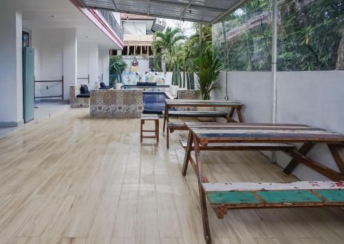 an empty room with wooden tables and benches at Margarita Surf Hostel Canggu in Canggu