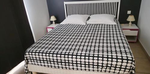 une chambre avec un lit avec une couverture noire et blanche dans l'établissement Grand T2 Meublé-Juan Pins-Logt8, à Antibes