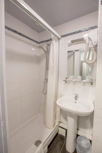 a white bathroom with a sink and a shower at Hipotel Paris Père-Lachaise République in Paris