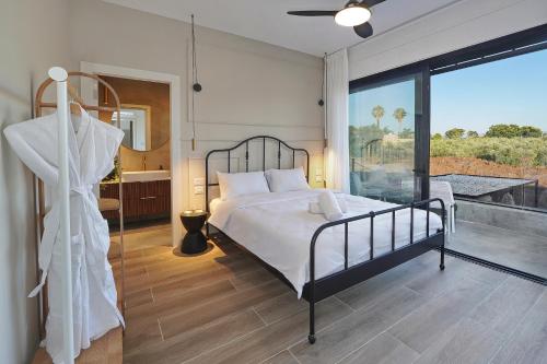 une chambre avec un lit et une grande fenêtre dans l'établissement אסיה ריזורט-Asia resort, à Mishmār Hāyardin