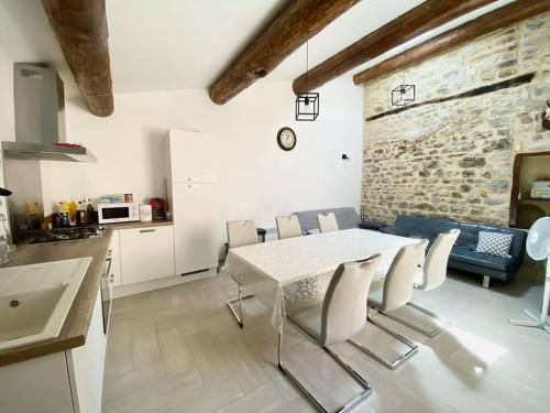 une cuisine et une salle à manger avec une table et des chaises dans l'établissement Maison de village à Ribeyret 2 à 4 pers à la Montagne WIFI, à Ribeyret