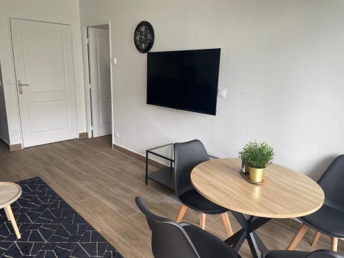 - un salon avec une table, des chaises et une télévision dans l'établissement Charmant deux pièces avec balcon, à Saint-Denis