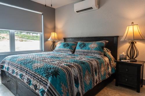 a bedroom with a bed and two lamps and a window at Willie In the Hill Country - Hacienda Amor in Johnson City