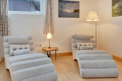 a living room with two chairs and a table at Haus Klinsterwald in Sankt Oswald