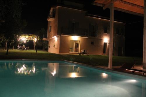 a swimming pool in front of a house at night at La Casa nell'Orto in Fermo