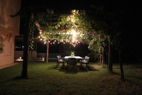 a table and chairs under a pergola at night at La Casa nell'Orto in Fermo
