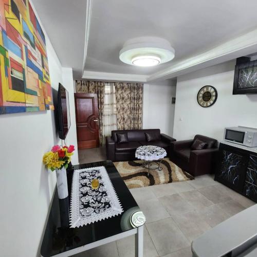 a living room with a couch and a table at Résidence FAMILIA PHOENIX in Douala