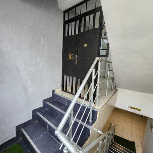 a set of stairs leading to a black door at Résidence FAMILIA PHOENIX in Douala