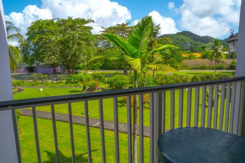 a balcony with a view of a park at Allamanda Beach Resort in Grand Anse