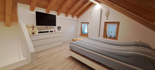 a bedroom with a bed and a flat screen tv at Chalet BORGO PRA' in Belluno