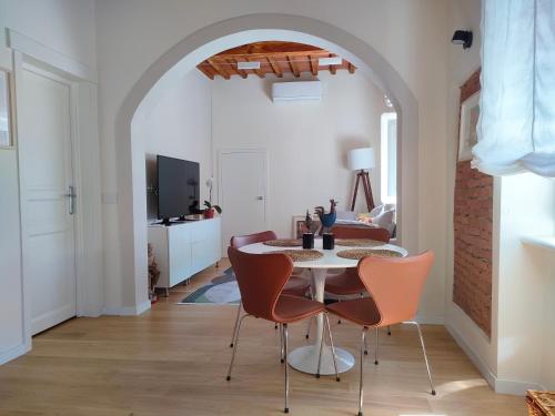 comedor con arco, mesa y sillas en Appartamento Pagal, en Pietrasanta