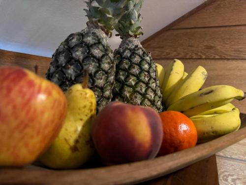 a bowl of fruit with apples oranges and bananas at Afford Hotéis in Lages
