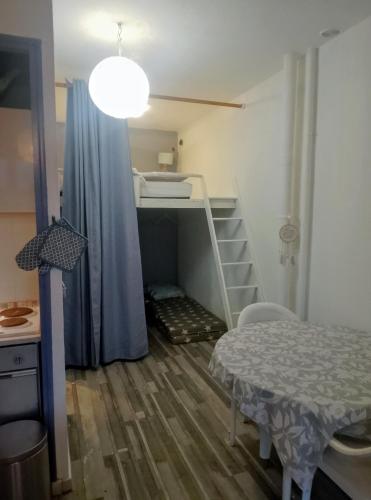 Cette petite chambre comprend des lits superposés et une table. dans l'établissement Petit nid douillet, à Argelès-sur-Mer