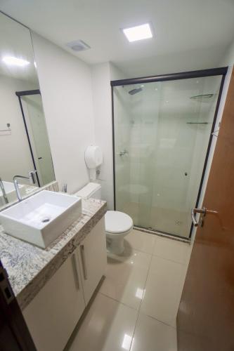 a bathroom with a sink and a toilet and a shower at Gold flat praia de cabo branco in João Pessoa