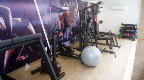 a gym with two women working out in the gym at Gold flat praia de cabo branco in João Pessoa