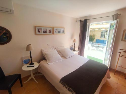 - une chambre avec un lit et une porte donnant sur une terrasse dans l'établissement Villa l'Olivaie, à Draguignan