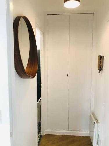 un couloir avec un miroir et une armoire blanche dans l'établissement Studio bord de mer, à Les Sables-dʼOlonne