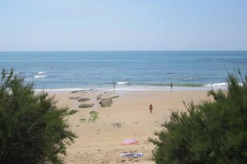 - une plage avec des gens sur le sable et l'océan dans l'établissement Studio bord de mer, à Les Sables-dʼOlonne